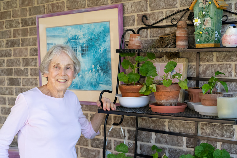 resident standing beside her plants