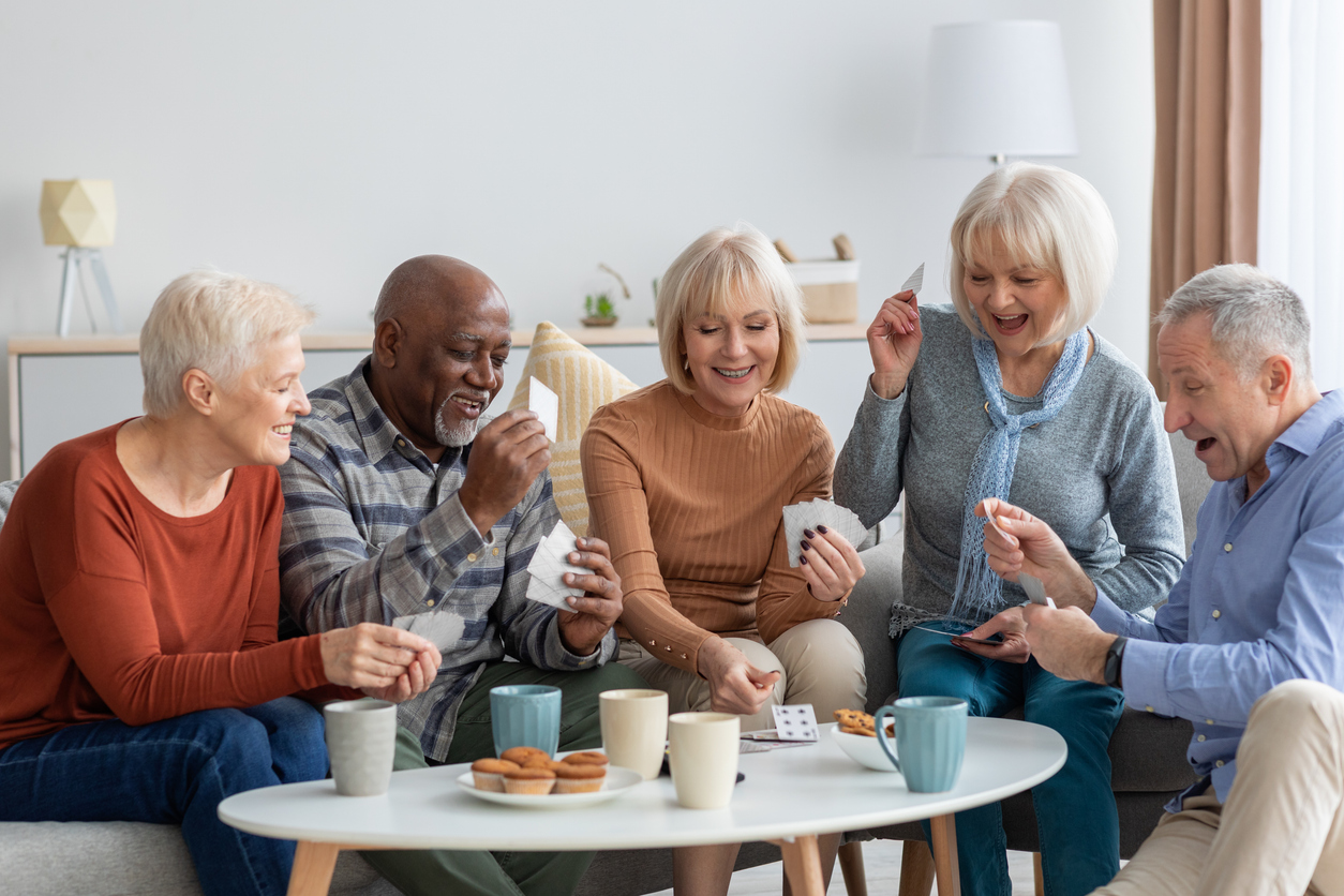 Group of senior adults sit together on couch.