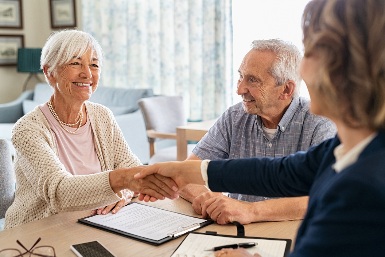 Senior adult couple shakes hands with admin.